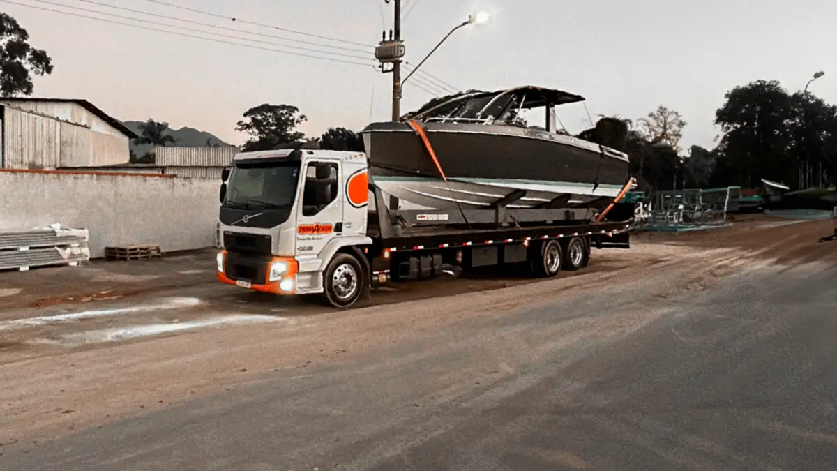 Caminhão Volvo da TransAcácio com lancha na prancha